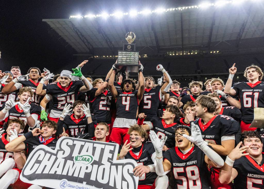 Archbishop Murphy holds up the 2A state championship trophy after beating Tumwater at Husky Stadium on Saturday, Dec. 6, 2025 in Seattle, Washington. (Olivia Vanni / The Herald)
