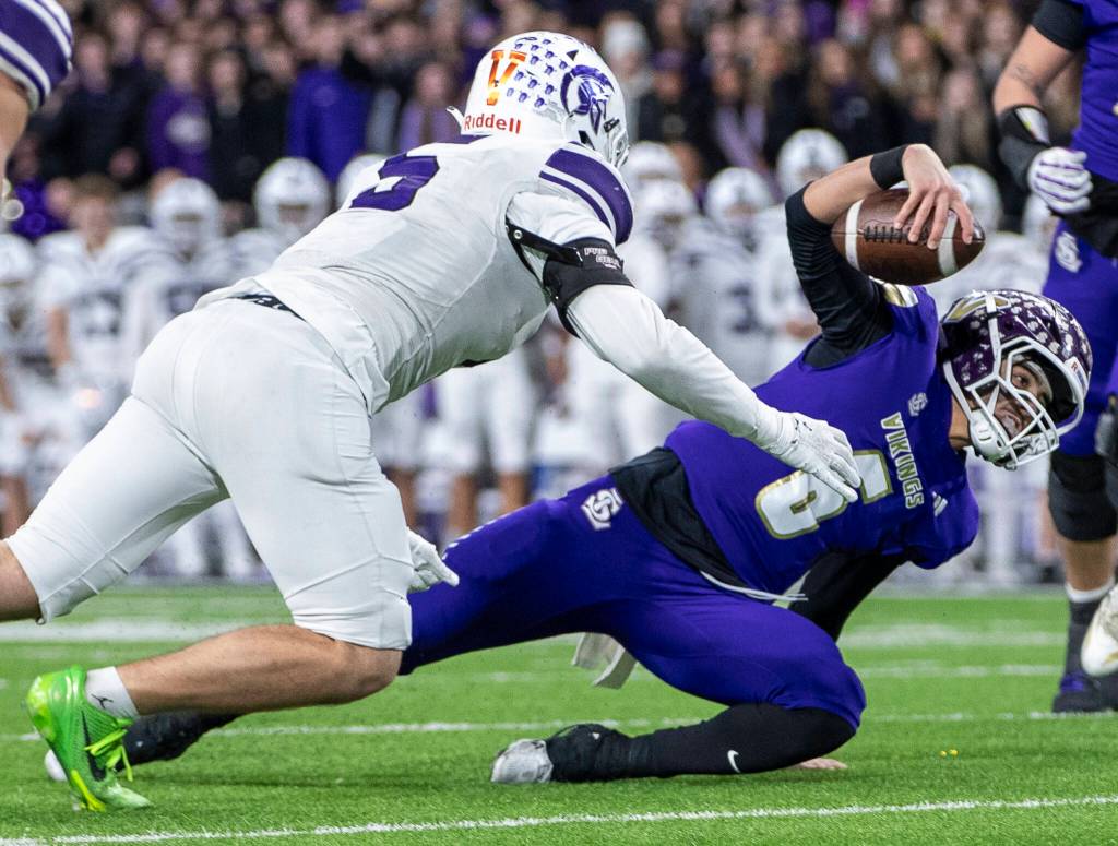 Lake Stevens Blake Moser slips while running the ball in overtime during the 4A state championship game against Sumner at Husky Stadium on Saturday, Dec. 6, 2025 in Seattle, Washington. (Olivia Vanni / The Herald)