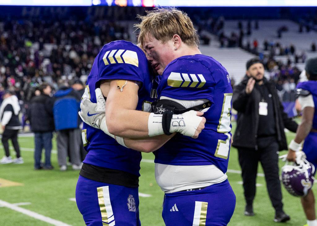 Lake Stevens Kayden Blanchard hugs his teammate after losing the 4A state championship game against Sumner at Husky Stadium on Saturday, Dec. 6, 2025 in Seattle, Washington. (Olivia Vanni / The Herald)