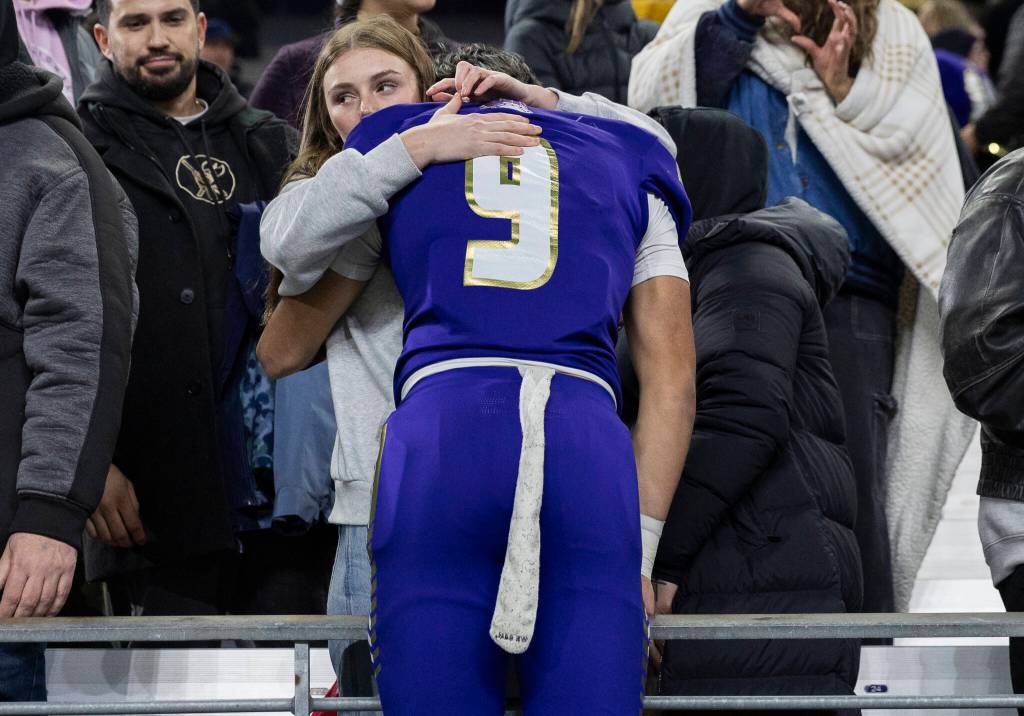 Lake Stevens Felix Ramsey is hugged after losing the 4A state championship game against Sumner at Husky Stadium on Saturday, Dec. 6, 2025 in Seattle, Washington. (Olivia Vanni / The Herald)