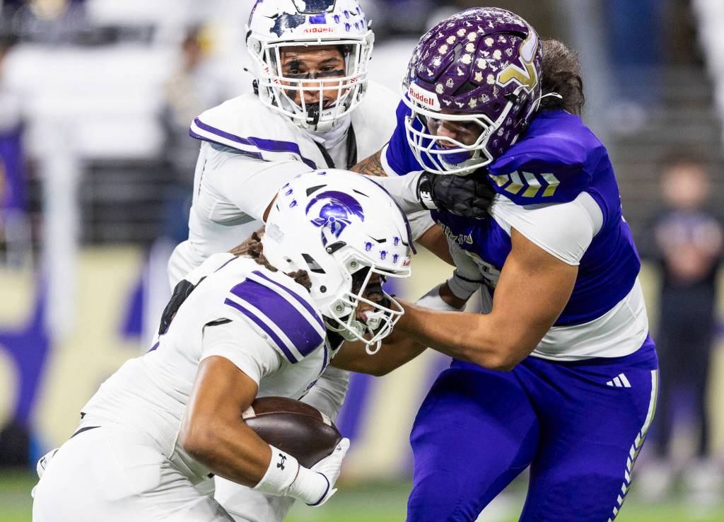 Lake Stevens Ty Tautolo tackles Sumners Lance McGee during the 4A state championship game at Husky Stadium on Saturday, Dec. 6, 2025 in Seattle, Washington. (Olivia Vanni / The Herald)