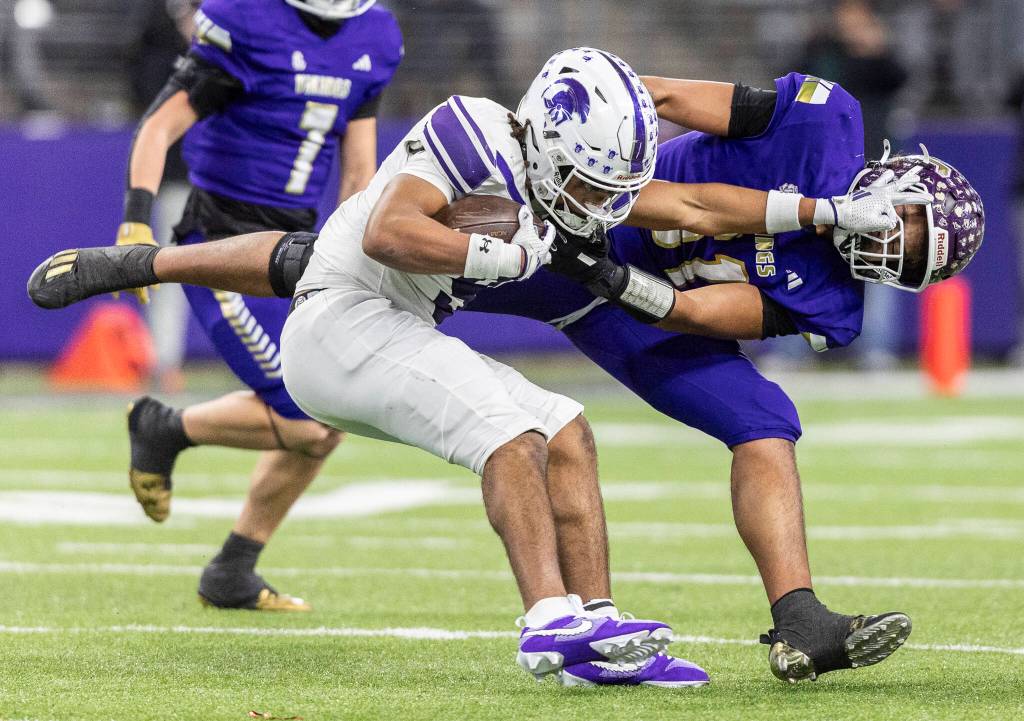 Sumners Lance McGee pushes Lake Stevens Kenny Buckmiller as he tries to tackle him during the 4A state championship game at Husky Stadium on Saturday, Dec. 6, 2025 in Seattle, Washington. (Olivia Vanni / The Herald)