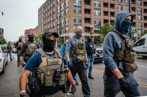 Masked federal agents arrive to help immigration agents detain immigrants and control protesters June 4 in Chicago. California in September became the first state to ban law enforcement officers from wearing face coverings, in response to immigration raids where federal agents wore masks. (Jamie Kelter Davis/The New York Times)