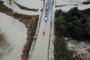 Drivers attempt to navigate floodwater from the Skykomish River covering Mann Road on Tuesday, Dec. 9, 2025 in Sultan, Washington. (Olivia Vanni / The Herald)