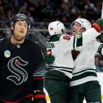 Brandon Montour (62) of the Seattle Kraken reacts as Marcus Johansson (90) of the Minnesota Wild celebrates his goal with Matt Boldy (12) of the Minnesota Wild during the third period at Climate Pledge Arena on December 08, 2025 in Seattle, Washington. (Steph Chambers / Getty Images / The Athletic)