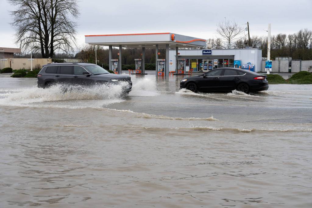 Drivers cross a flooded street on Thursday, Dec. 11 in Arlington, Washington. (Will Geschke / The Herald)