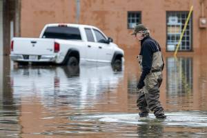 Bob Hammond wades through the water covering Main Street on Thursday, Dec. 11, 2025 in Sultan, Washington. (Olivia Vanni / The Herald)