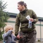 Ashlie Coffin holds the hand of her son Junior, 2, outside of the Evergreen State Fairgrounds Red Cross disaster relief shelter where her and her two sons have been staying for the last two days after their trailer at Three Rivers Mobile Home Park flooded on Friday, Dec. 12, 2025 in Monroe, Washington. (Olivia Vanni / The Herald)