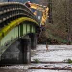 Snohomish County workers try to remove trees and other debris stuck on the Mann Road Bridge on Thursday, Dec. 11, 2025 in Sultan, Washington. (Olivia Vanni / The Herald)