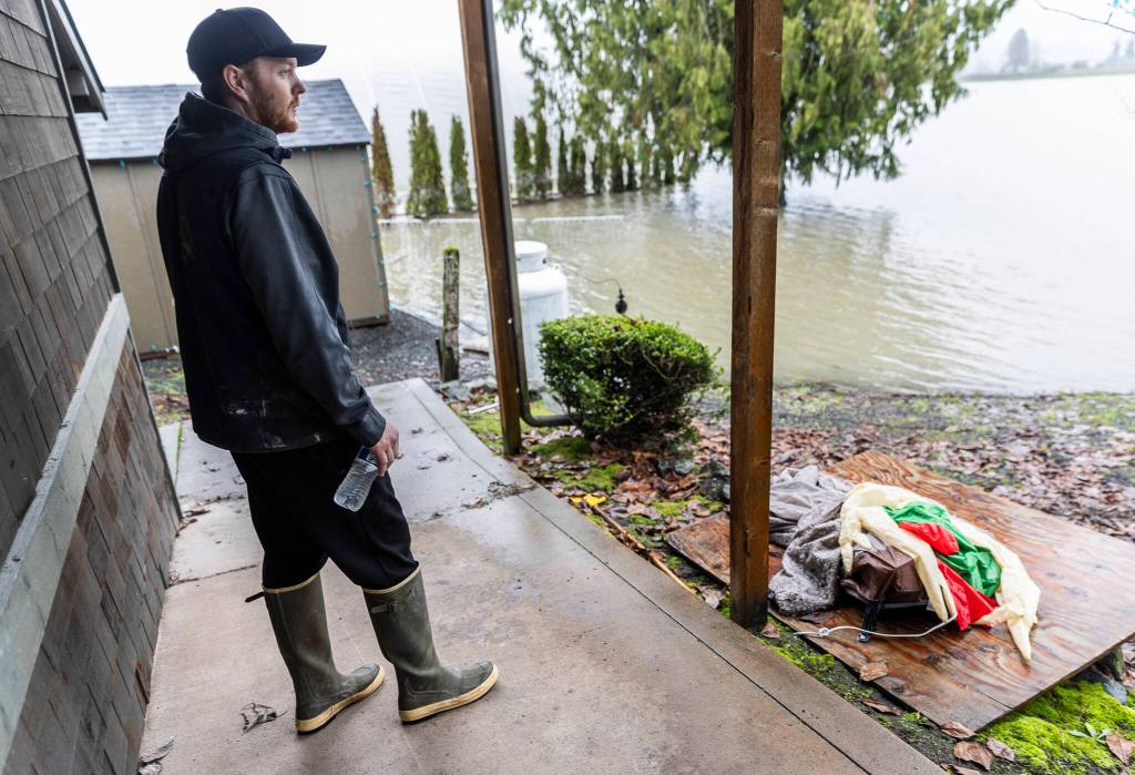 Mick Stocker looks out over the fields that are still flooded behind the Hidden Meadows buildings on Tuesday, Dec. 16, 2025 in Snohomish, Washington. (Olivia Vanni / The Herald)