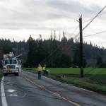 Snohomish County PUD crews work to repair power lines on Wednesday along Marine Drive in Stanwood. (Will Geschke / The Herald)