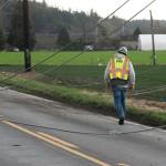 Snohomish County PUD crews work to repair power lines on Wednesday along Marine Drive in Stanwood. (Will Geschke / The Herald)