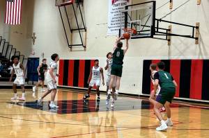 Edmonds-Woodway junior Lincoln Bradley (0) elevates to the rim during the Warriors' 74-47 win against Archbishop Murphy at Archbishop Murphy High School on Dec. 17, 2025. (Herald Staff)
