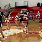 Stanwood senior Presley Harris attempts to hold off Jackson junior Mackenzie Pepin (right, wearing black) at the perimeter during the Spartans' 52-44 win against the Timberwolves at Stanwood High School on Dec. 18, 2025. (Herald Staff)