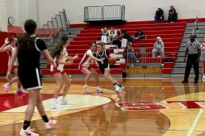 Stanwood senior Presley Harris attempts to hold off Jackson junior Mackenzie Pepin (right, wearing black) at the perimeter during the Spartans' 52-44 win against the Timberwolves at Stanwood High School on Dec. 18, 2025. (Herald Staff)