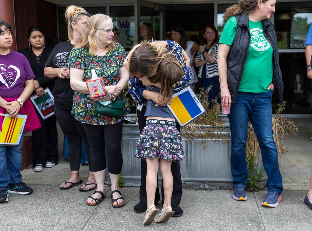 Student Azhura Brown, 5, hugs teacher Anzhelika Huliar on Wednesday, June 25, 2025, in Everett, Washington. (Olivia Vanni / The Herald)