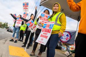 Nory Hang, right, watches cars pass by while picketing with fellow Boeing workers on strike along Airport Road on Monday, Sept. 16, 2024 in Everett, Washington. (Olivia Vanni / The Herald)