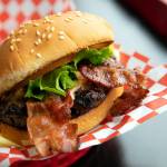 Ryan Berry / The Herald
Nicks Jr.s peanut butter bacon burger glistens in the light on March 31, 2023, at the restaurant in Everett. The burger consists of a seasoned patty with melty Skippy Super Chunk peanut butter, two bacon slices, lettuce, tomato and mayo on a toasted sesame seed bun.