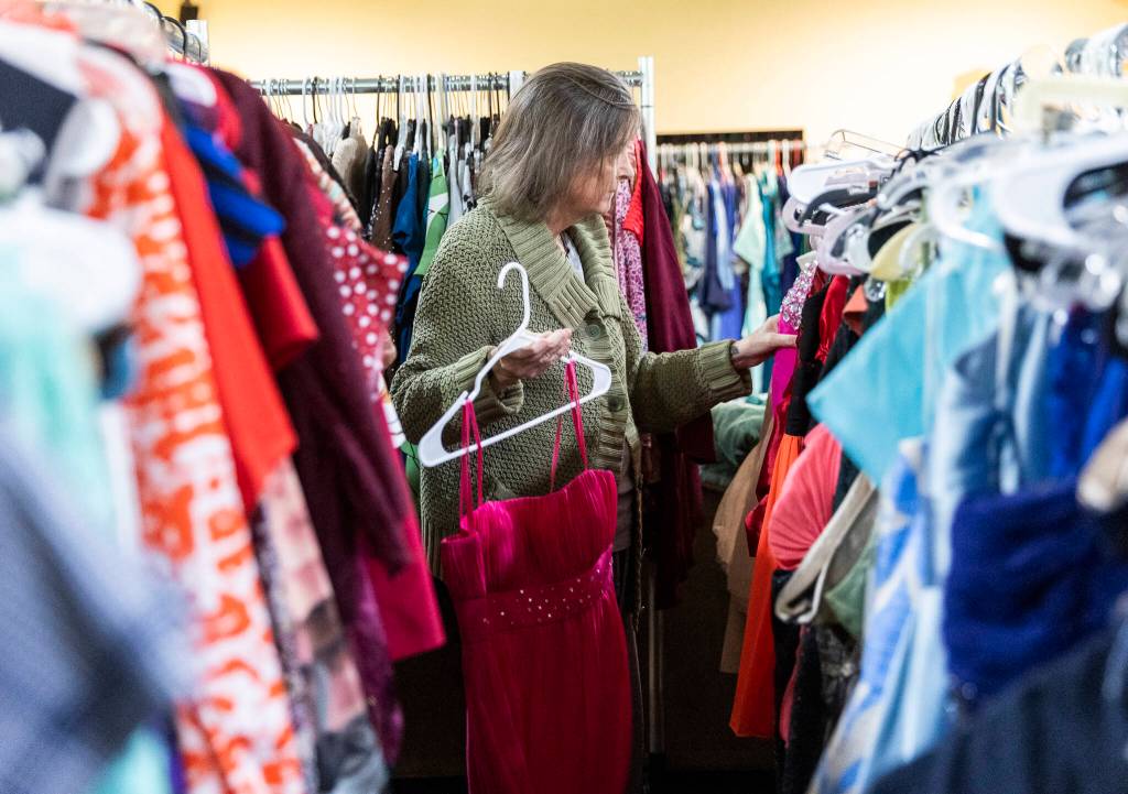 Jana Clark picks out a selection of dress that could be used for prom on Wednesday, May 14, 2025 in Snohomish, Washington. (Olivia Vanni / The Herald)