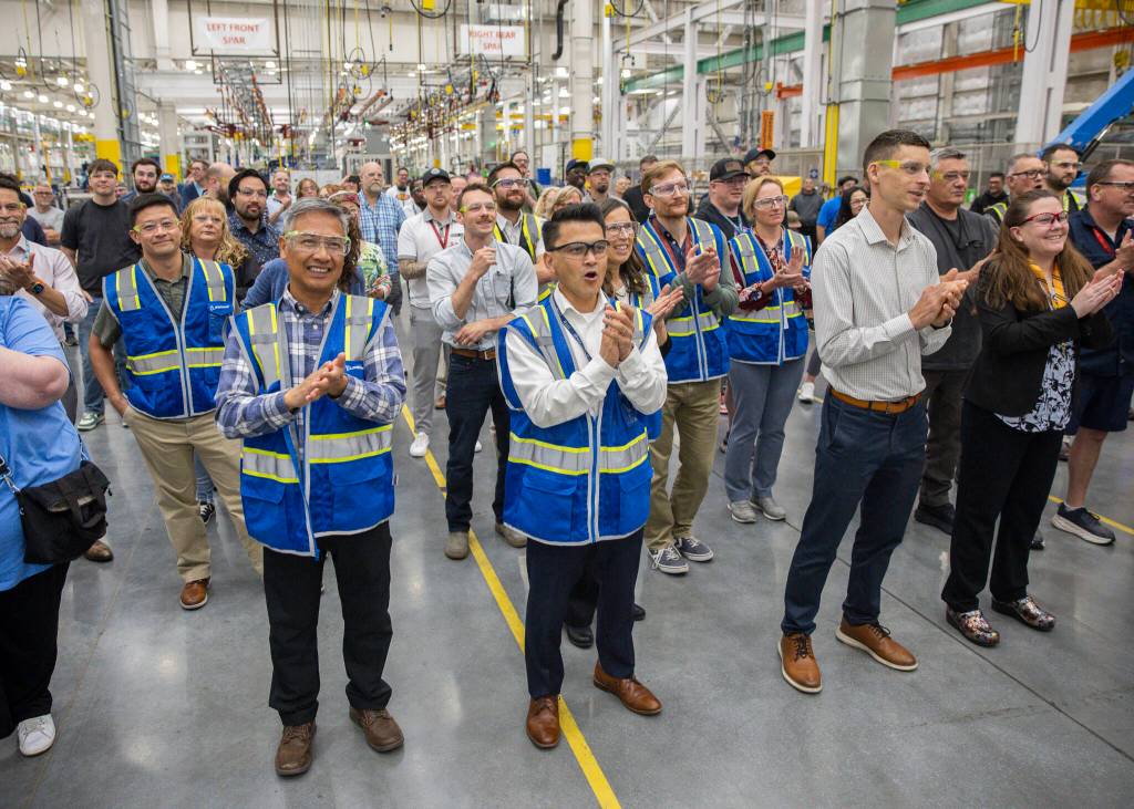 Olivia Vanni / The Herald
Richard Wong, center, the 777-X wing engineering senior manager, cheers as the first hole is drilled in the 777-8 Freighter wing spar on Monday, July 21 in Everett.