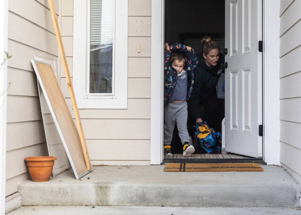 Raiden, 4, puts his jacket on and walks out the front door on Tuesday, Dec. 30, 2025 in Marysville, Washington. (Olivia Vanni / The Herald)
