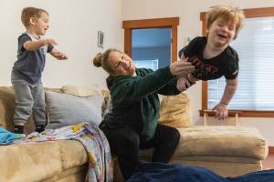 Stephanie Boyle tosses Oaklen, 2, onto a padded mat before getting her sons ready for daycare on Tuesday, Dec. 30, 2025 in Marysville, Washington. (Olivia Vanni / The Herald)
