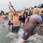 Jonni Ng runs into the water at Bracketts Landing North during the 19th annual Polar Bear Plunge on Thursday, Jan. 1, 2026, in Edmonds, Washington. The plunge at Bracketts Landing beach was started by Brian Taylor, the owner of Daphnes Bar. (Olivia Vanni / The Herald)
