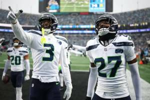 Nick Emmanwori (3) and Riq Woolen (27) react after Julian Love (20) of the Seattle Seahawks intercepted a pass during the third quarter against the Carolina Panthers at Bank of America Stadium on December 28, 2025 in Charlotte, North Carolina. (Jared C. Tilton / Getty Images / The Athletic)
