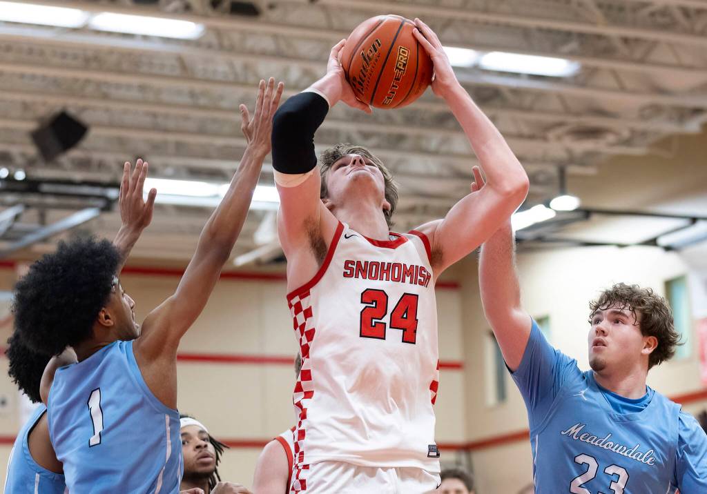 Snohomishs Luke Davis rebounds the ball over Meadowdales Noah Million and Marley Miller during the game on Monday, Jan. 5, 2026 in Snohomish, Washington. (Olivia Vanni / The Herald)