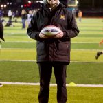 Monroe girls flag football coach Connor Wood poses with the Coach of the Game football, which he received along with a $1,000 donation to the Bearcats program after they defeated Ferndale 21-14 at the Seattle Seahawks takeover event at Everett Memorial Stadium on Jan. 7, 2026. (Joe Pohoryles / The Herald)