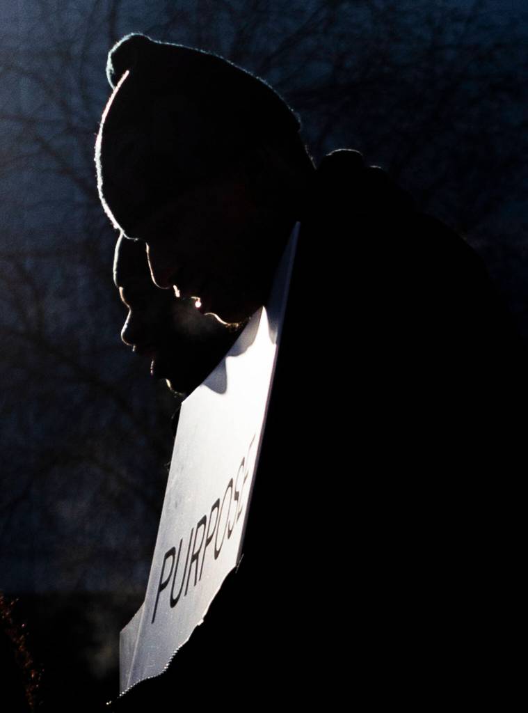 People hold a sign with the word purpose as they walk down Wall Street on Monday, Jan. 19, 2026 in Everett, Washington. (Olivia Vanni / The Herald)