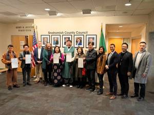 Mukilteo City Council member Jason Moon (center) stands with his parents, Washingtons Korean consul general and members of the Snohomish County Council, holding the resolution recognizing Korean American Day on Jan. 13, 2026. (Taylor Scott Richmond / The Herald)