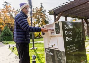 Eric Rasmussen drops his ballot in the ballot box outside of Town of Woodway Town Hall on Nov. 4, 2025 in Edmonds, Washington. (Olivia Vanni / The Herald)