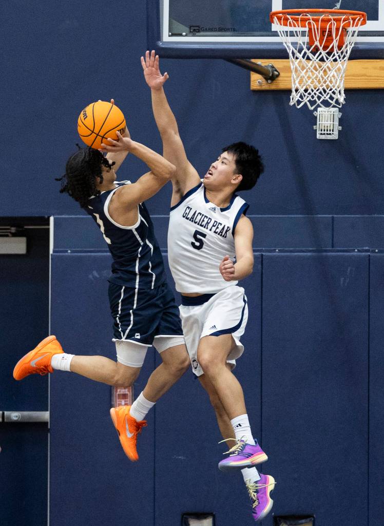 Glacier Peaks Edison Kan blocks a shot by Arlingtons Mac Crews during the game on Friday, Jan. 16, 2026 in Snohomish, Washington. (Olivia Vanni / The Herald)