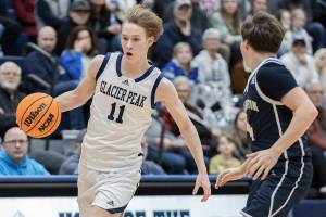 Glacier Peak’s Reed Nagel takes the ball up the court against Arlington’s Maveric Vaden during the game on Friday, Jan. 16, 2026 in Snohomish, Washington. (Olivia Vanni / The Herald)