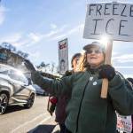 Barbara and Anne Guthrie holds signs and wave at cars offloading from the ferry during South Snohomish County Indivisibles Signs of Fascism protest on Tuesday, Jan. 20, 2026 in Edmonds, Washington. (Olivia Vanni / The Herald)