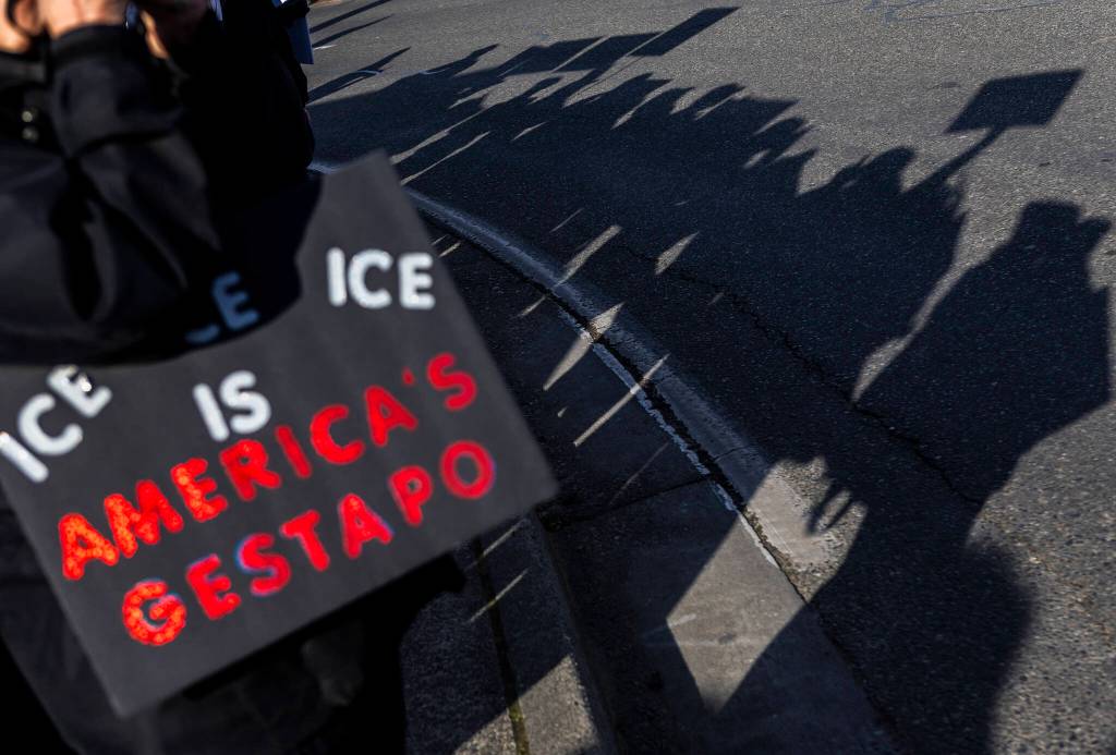 People wave signs during South Snohomish County Indivisibles Signs of Fascism protest on Tuesday, Jan. 20, 2026 in Edmonds, Washington. (Olivia Vanni / The Herald)