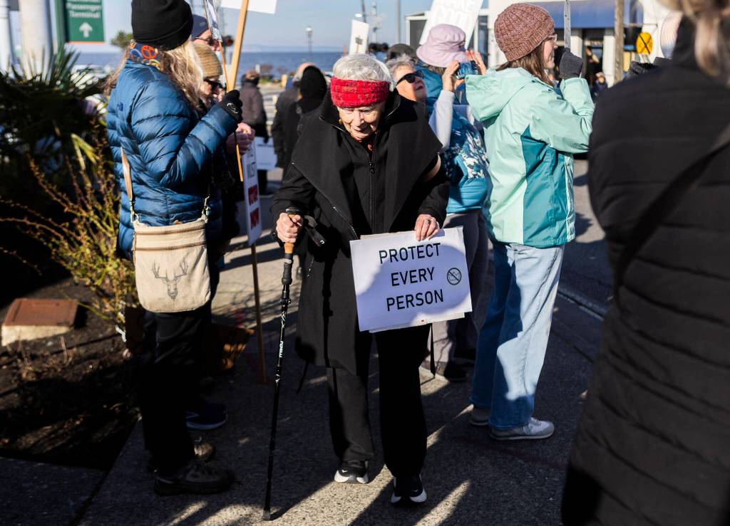 Clara Cleve, 86, holds a sign in protest of ICEs recent actions in the United States during South Snohomish County Indivisibles Signs of Fascism protest on Tuesday, Jan. 20, 2026 in Edmonds, Washington. (Olivia Vanni / The Herald)