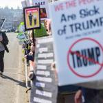 People hold signs and walk along Sunset Avenue during South Snohomish County Indivisibles Signs of Fascism protest on Tuesday, Jan. 20, 2026 in Edmonds, Washington. (Olivia Vanni / The Herald)