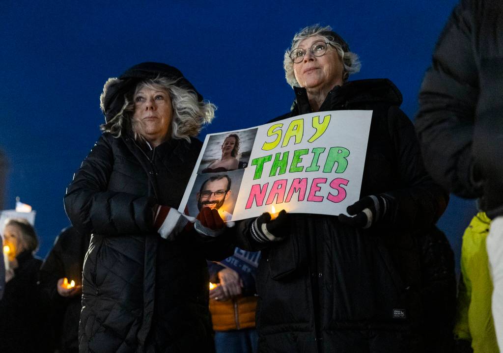 Laurie Hardie and Tammie Enders holds a sign with photographs of Renee Good and Alex Pretti during a vigil held outside of the Snohomish County Courthouse on Tuesday, Jan. 27, 2026, in Everett, Washington. (Olivia Vanni / The Herald)