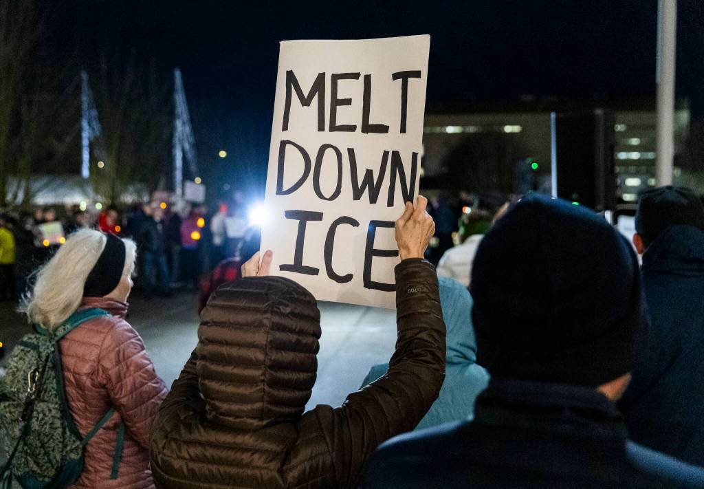 A person holds an anti-ICE sign during a vigil held at the Snohomish County Campus as a show of solidarity with the city of Minneapolis as the Midwest city faces a dramatic uptick in immigration enforcement on Tuesday, Jan. 27, 2026, in Everett, Washington. (Olivia Vanni / The Herald)