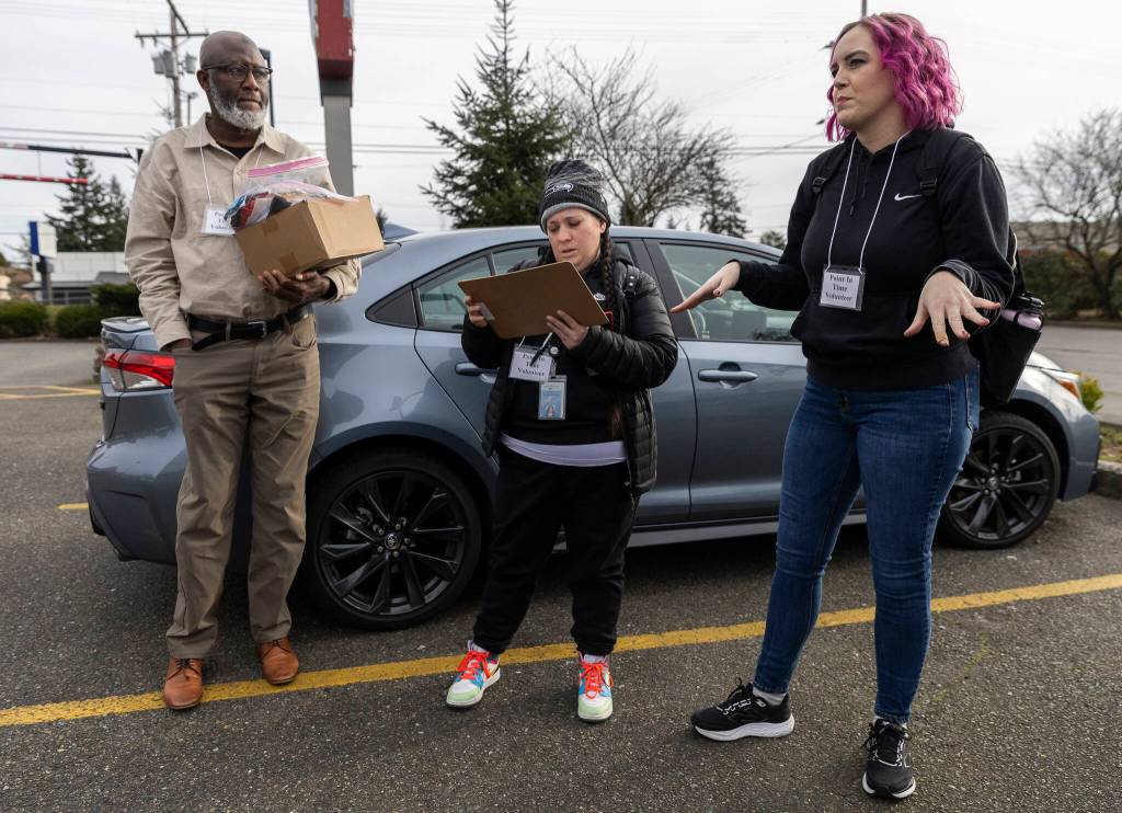 Jobe Momodouon, Rachel McGee and Amanda Amoruso talk before heading out for their Point In Time count shift on Tuesday, Jan. 27, 2026, in Everett, Washington. (Olivia Vanni / The Herald)