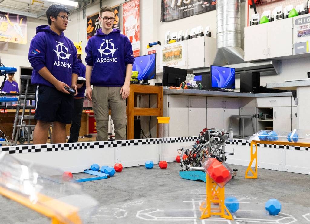 Chris Rapues and Riley Walrod runs their robot through a series of tasks on Thursday, Jan. 29, 2026 in Lake Stevens, Washington. (Olivia Vanni / The Herald)