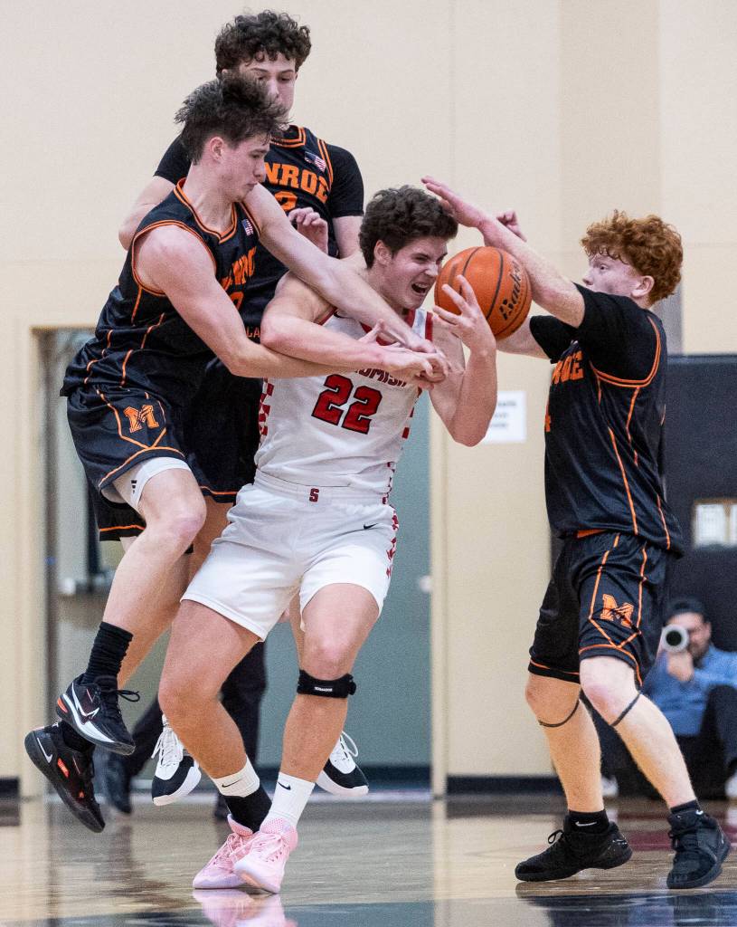 Snohomishs Deyton Wheat tries to keep possession of the ball while being guarded by multiple Monroe players during the game on Wednesday, Jan. 28, 2026 in Snohomish, Washington. (Olivia Vanni / The Herald)