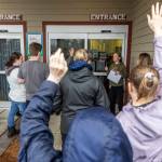 People raise their hands to volunteer to foster the remains dogs at the Everett Animal Shelter on Wednesday, Dec. 10, 2025 in Everett, Washington. (Olivia Vanni / The Herald)