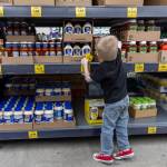 Elias Sundem, 3, organizes a shelf inside the Grocery Outlet on Tuesday, Feb. 10, 2026 in Everett, Washington. (Olivia Vanni / The Herald)