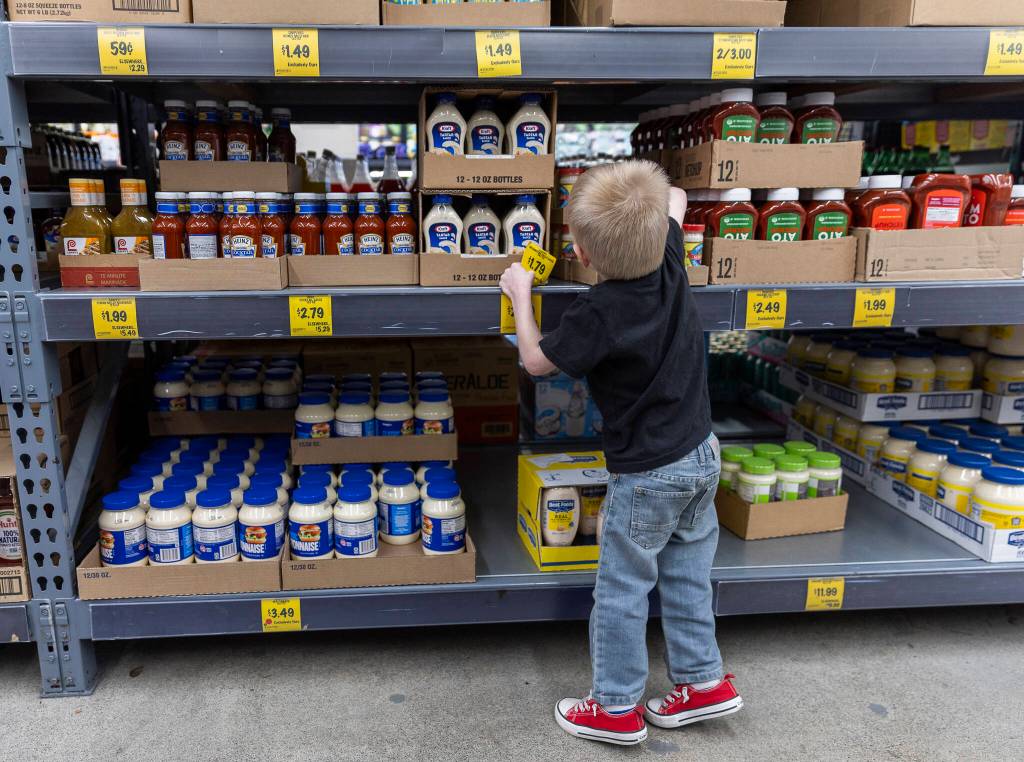 Elias Sundem, 3, organizes a shelf inside the Grocery Outlet on Tuesday, Feb. 10, 2026 in Everett, Washington. (Olivia Vanni / The Herald)