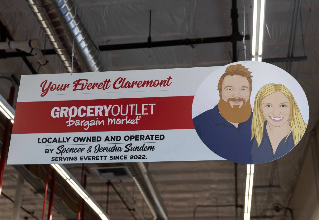 A sign and photo of the Sundems hangs above the main door inside the Grocery Outlet on Tuesday, Feb. 10, 2026 in Everett, Washington. (Olivia Vanni / The Herald)