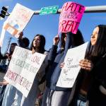 Alia Hueso, left to right, Asha Fofana, and Analia Castillo, sophomores at Lakewood High School, hold signs during a student walkout and protest on Thursday, Feb. 5, 2026 in Marysville, Washington. (Olivia Vanni / The Herald)