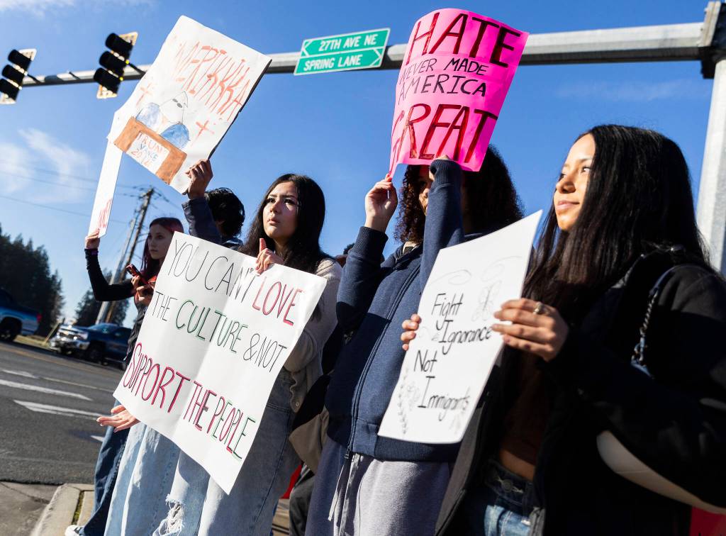 Alia Hueso, left to right, Asha Fofana, and Analia Castillo, sophomores at Lakewood High School, hold signs during a student walkout and protest on Thursday, Feb. 5, 2026 in Marysville, Washington. (Olivia Vanni / The Herald)